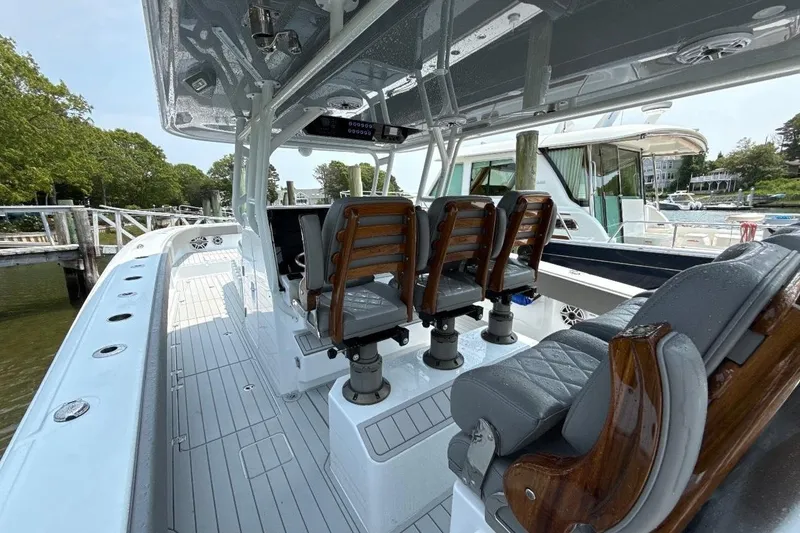 Slide: The Image of 2025 Freeman 42 LR boat interior with sleek seating and modern design at a marina. - 19