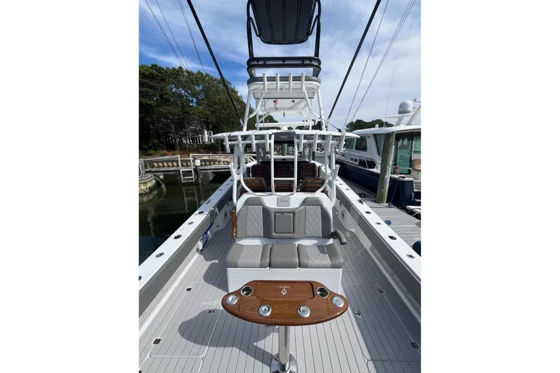 Slide: The Image of 2025 Freeman 42 LR boat interior with seating and fishing rod holders, docked at marina. - 21