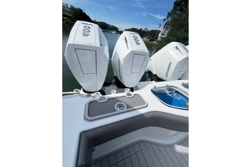 Slide: The Image of 2025 Freeman 42 LR boat with triple Mercury 400 engines on a calm waterway. - 23