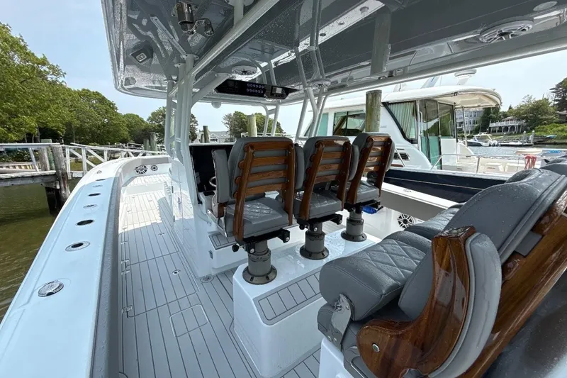 Slide: The Image of 2025 Freeman 42 LR boat interior with sleek seating and modern design at a marina. - 24