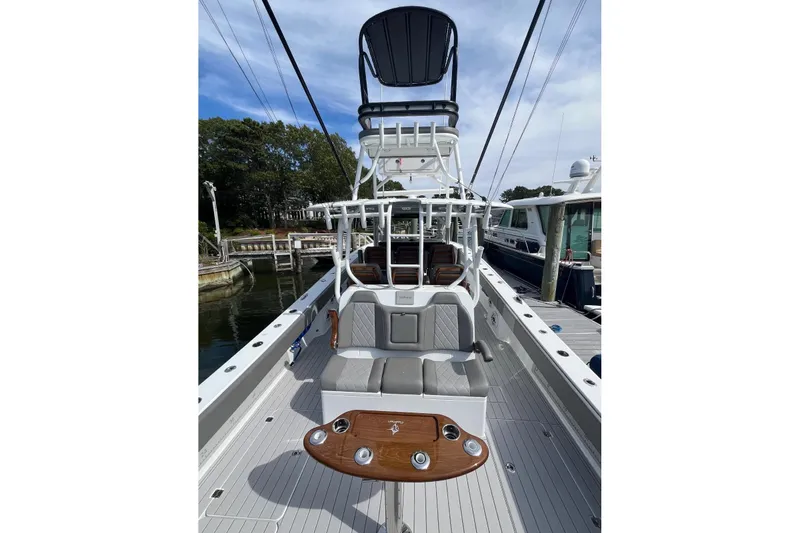 Slide: The Image of 2025 Freeman 42 LR boat with elevated seating and sleek design at a marina. - 25