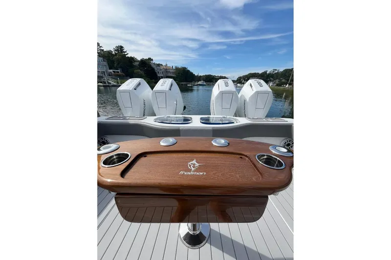 Slide: The Image of 2025 Freeman 42 LR boat with four powerful outboard engines and elegant wooden table. - 30