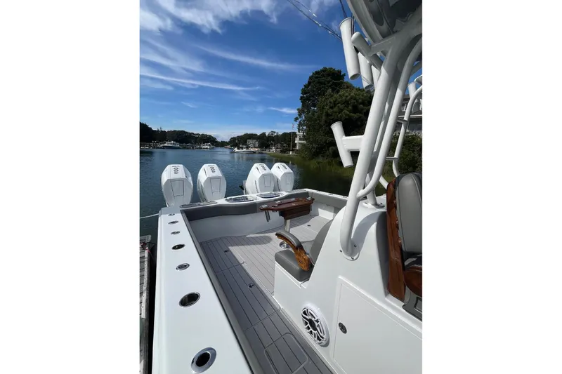 Slide: The Image of 2025 Freeman 42 LR boat with multiple engines docked on a scenic waterway. - 31