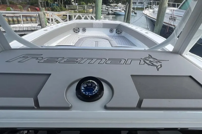 Slide: The Image of Freeman 42 LR 2025 boat dashboard with compass, docked in marina. - 33