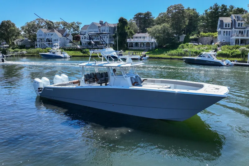 Slide: The Image of 2025 Freeman 42 LR boat on a serene waterfront with houses in the background. - 4