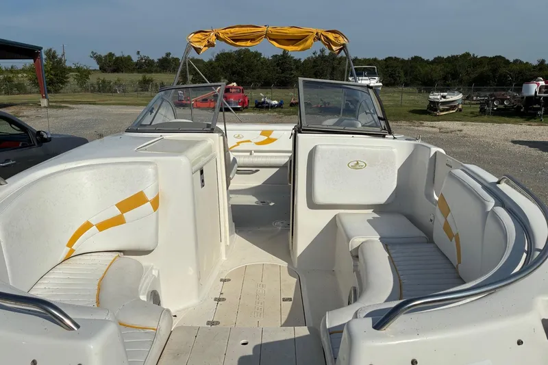 Slide: The Image of 2004 Ebbtide Campione 210 boat interior with yellow accents and seating. - 4