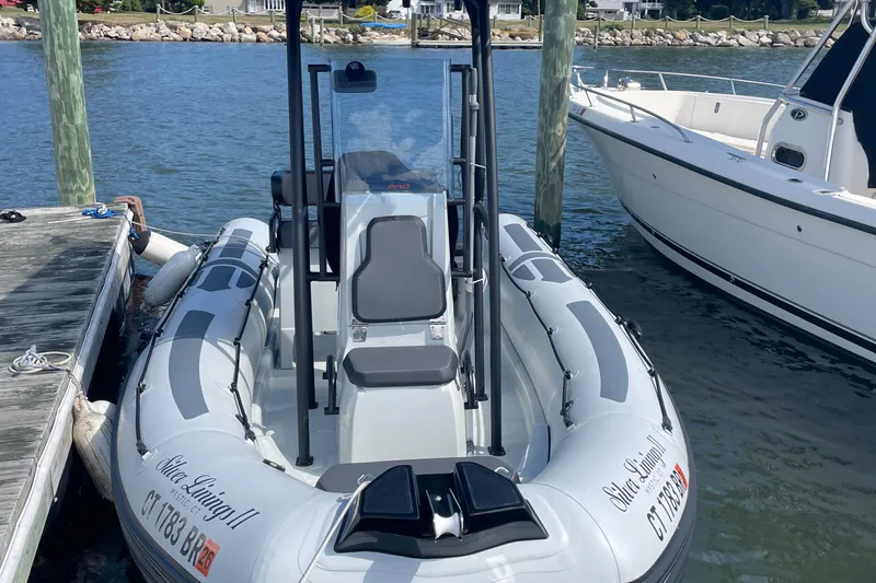Slide: The Image of 2025 Zodiac Pro 5.5 inflatable boat docked on calm water. - 7