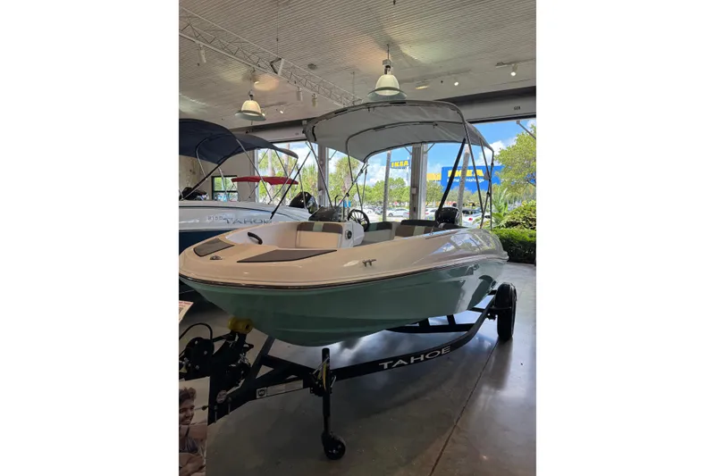 The Image of 2026 Tahoe T16 boat displayed indoors with canopy and trailer. - 0