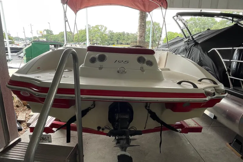 Slide: The Image of 2007 Tahoe 195s boat with red accents, docked under a canopy. - 3