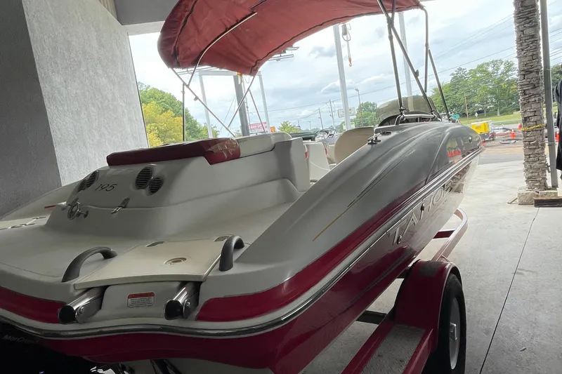 Slide: The Image of 2007 Tahoe 195s boat with red canopy, parked on a trailer in a covered area. - 4