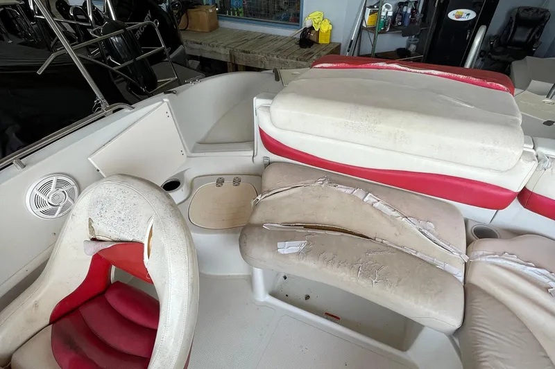 Slide: The Image of 2007 Tahoe 195s boat interior with worn, torn red and white seating. - 6