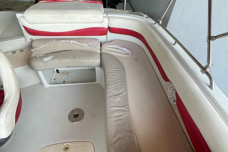 Slide: The Image of 2007 Tahoe 195s boat interior with worn red and white seating. - 7