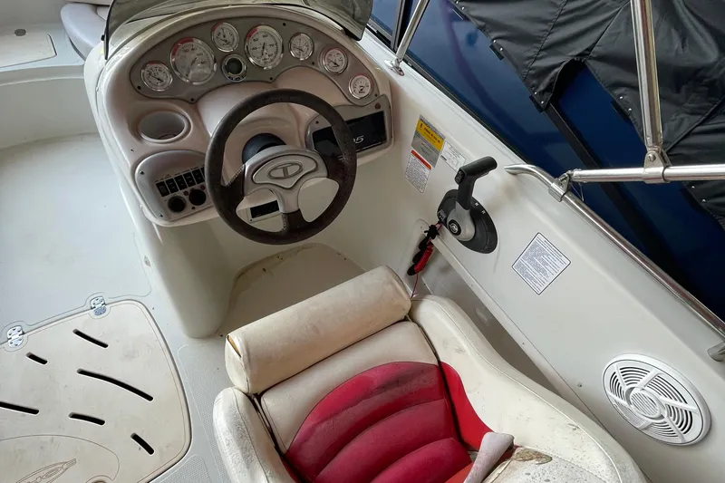 Slide: The Image of 2007 Tahoe 195s boat cockpit with steering wheel, gauges, and red seat. - 8