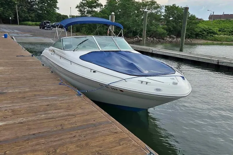 The Image of 1999 Sea Ray 280 Bow Rider docked with blue cover and canopy. - 0