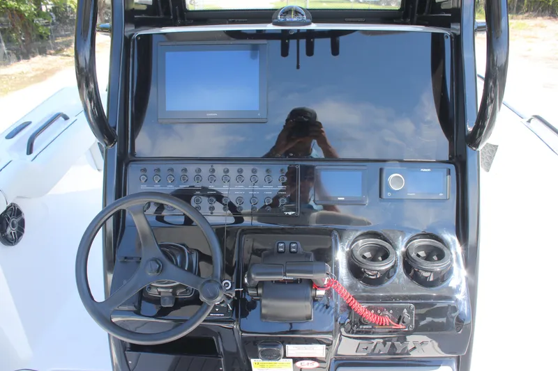 Slide: The Image of 2026 Tidewater 256 CC Adventure boat dashboard with steering wheel and electronic controls. - 14