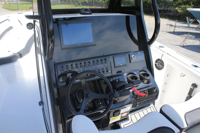 Slide: The Image of 2026 Tidewater 256 CC Adventure boat dashboard with steering wheel and control panel. - 15