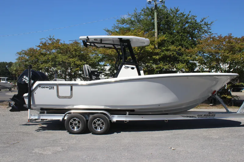 Slide: The Image of 2026 Tidewater 256 CC Adventure boat on trailer, side view, outdoors. - 2