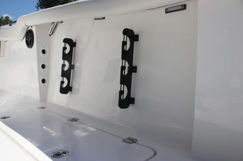 Slide: The Image of 2026 Tidewater 256 CC Adventure boat interior with rod holders and speaker. - 22