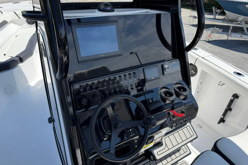 Slide: The Image of 2026 Tidewater 256 CC Adventure boat console with steering wheel and electronic controls. - 27
