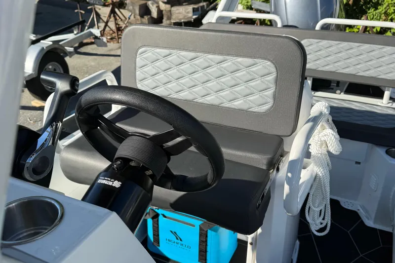 Slide: The Image of 2024 Highfield Sport 560 boat interior with steering wheel and quilted seating. - 17
