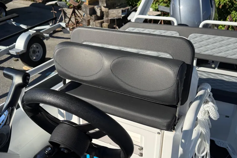 Slide: The Image of 2024 Highfield Sport 560 boat interior with steering wheel and cushioned seating. - 18