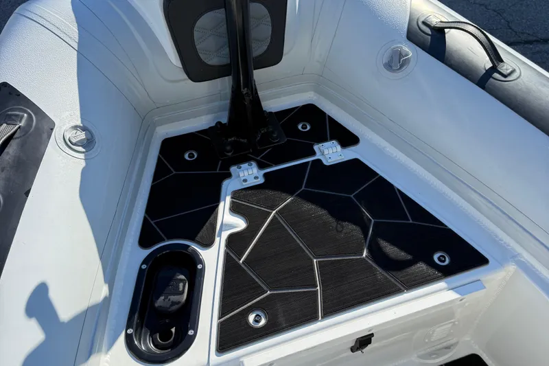 Slide: The Image of 2024 Highfield Sport 560 boat interior with black geometric flooring and storage compartments. - 24
