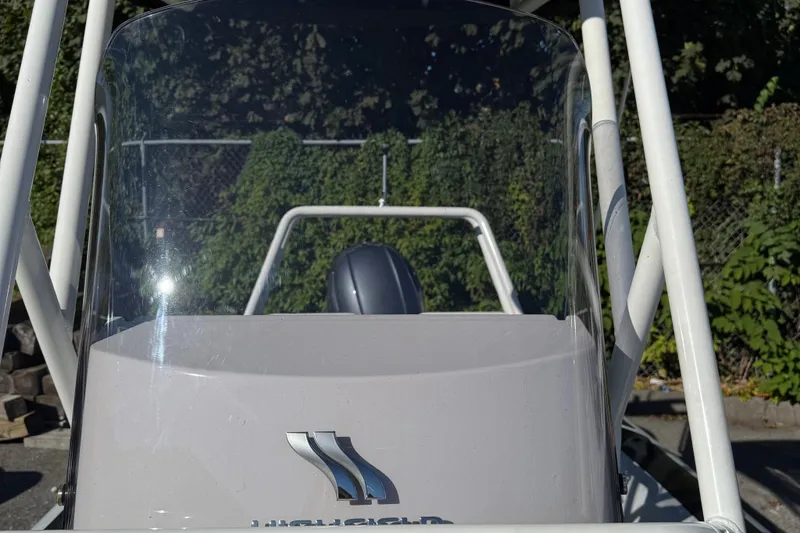 Slide: The Image of 2024 Highfield Sport 560 boat with windshield and logo, outdoor setting. - 27