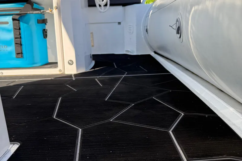 Slide: The Image of 2024 Highfield Sport 560 boat interior with black geometric flooring and blue storage box. - 28