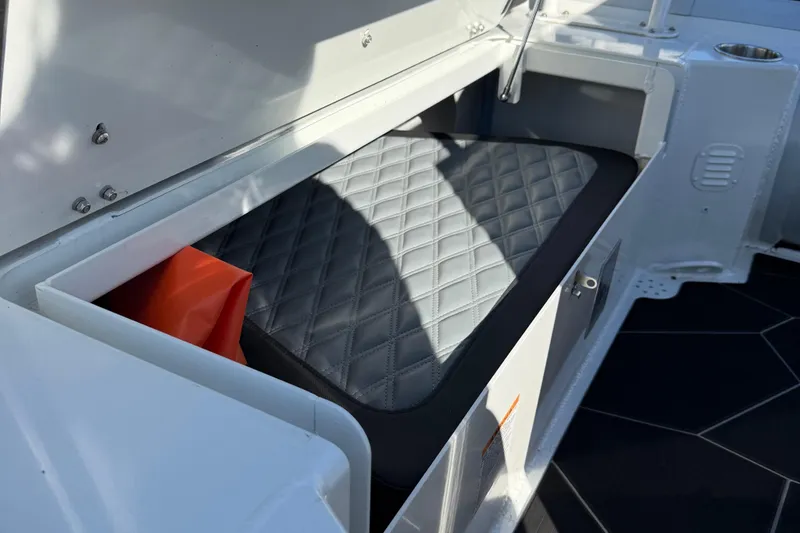 Slide: The Image of 2024 Highfield Sport 560 boat storage compartment with quilted cushion and orange accessory. - 35