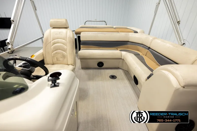 Slide: The Image of 2011 Misty Harbor 2285 CS pontoon boat interior with beige seating and steering console. - 14