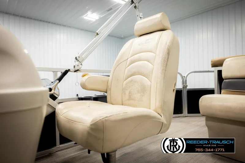 Slide: The Image of 2011 Misty Harbor 2285 CS boat interior with beige captain's chair in a showroom. - 34