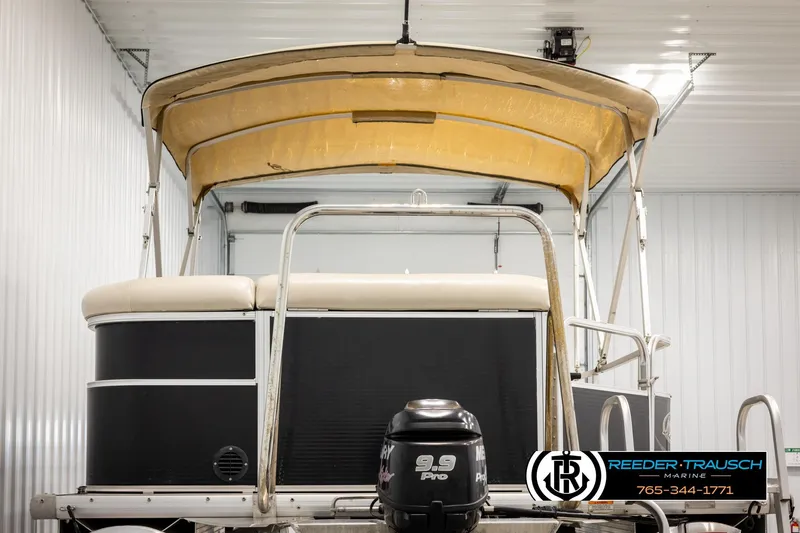 Slide: The Image of 2011 Misty Harbor 2285 CS pontoon boat with canopy and outboard motor in storage. - 7