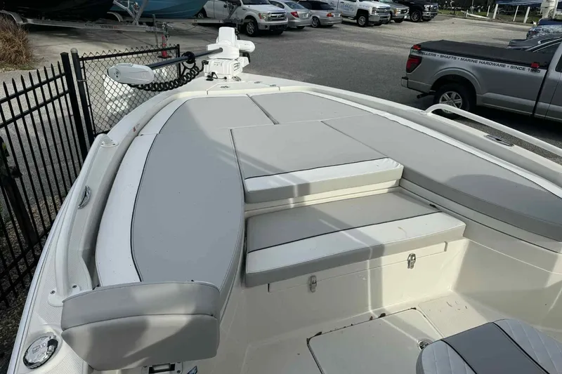 Slide: The Image of 2026 Ranger 2510 Bay boat with cushioned seating and storage, parked near vehicles. - 3