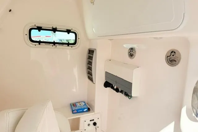 Slide: The Image of 2014 Everglades 325 Center Console boat with white cushioned seating and armrests. - 19