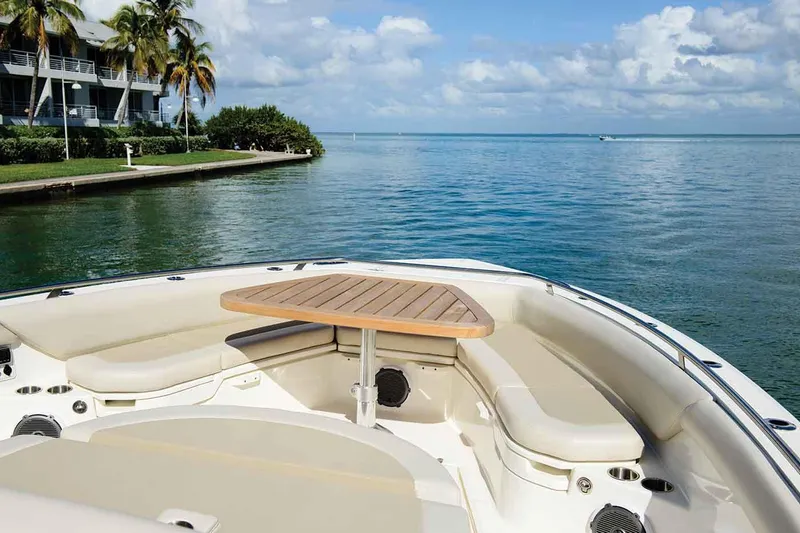 Slide: The Image of Manufacturer Provided Image: 2020 Boston Whaler 420 Outrage boat with seating area and table, docked near tropical shoreline. - 5