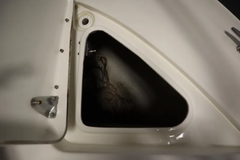 Slide: The Image of Storage compartment on a 2013 Sea Ray 280 Sundancer boat, featuring a coiled rope. - 14