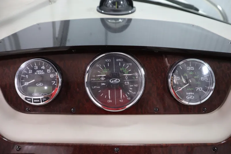 Slide: The Image of Dashboard of a 2013 Sea Ray 280 Sundancer boat with gauges and controls. - 26