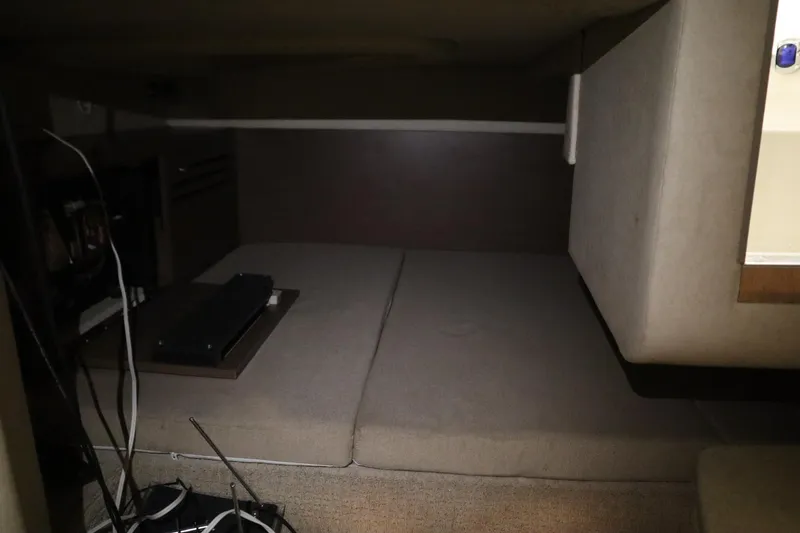 Slide: The Image of 2013 Sea Ray 280 Sundancer cabin interior with cushioned seating and storage area. - 64