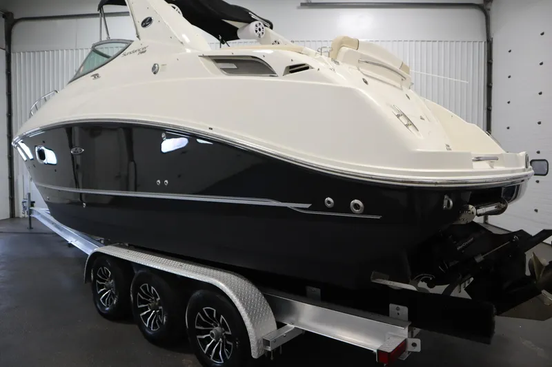 Slide: The Image of 2013 Sea Ray 280 Sundancer boat on trailer in indoor storage. - 7