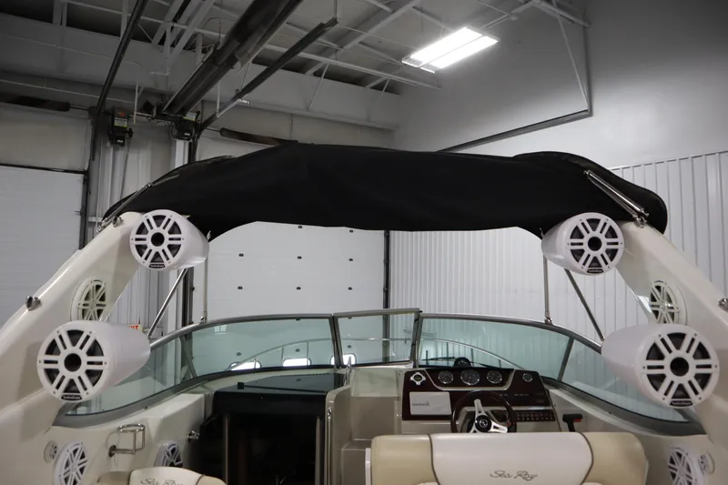 Slide: The Image of 2013 Sea Ray 280 Sundancer interior with speakers and dashboard in a garage setting. - 73