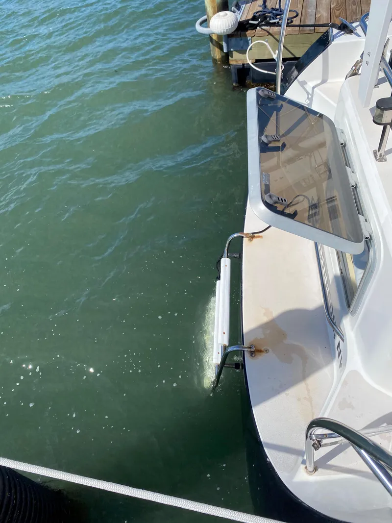 Slide: The Image of 1997 Catalina Morgan 38 sailboat docked, showing stern and water ladder. - 25