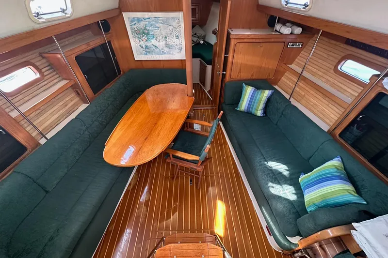 Slide: The Image of Cozy interior of 1997 Catalina Morgan 38 sailboat with green seating and wooden table. - 32