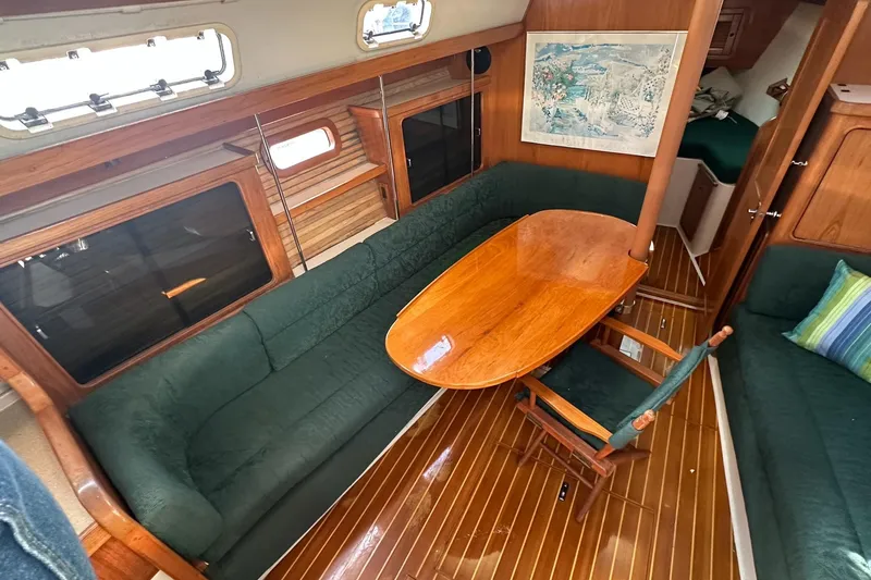 Slide: The Image of Interior of 1997 Catalina Morgan 38 sailboat with wooden table and green seating. - 33