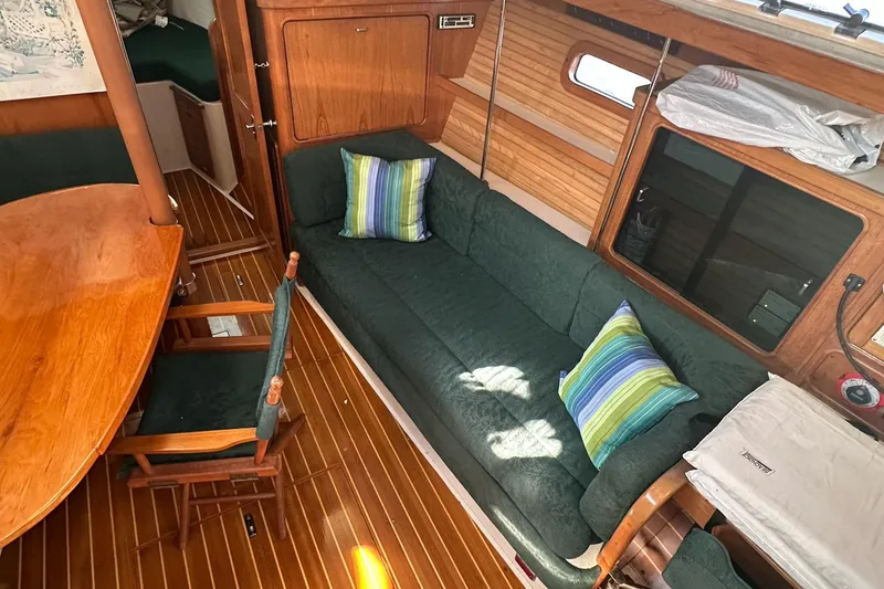 Slide: The Image of Cozy interior of 1997 Catalina Morgan 38 sailboat with green seating and wooden accents. - 34