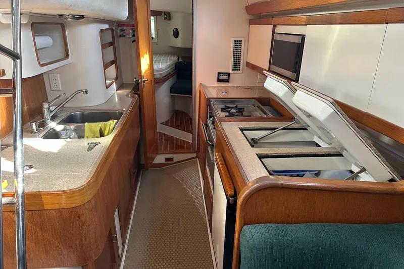 Slide: The Image of Interior of 1997 Catalina Morgan 38 sailboat kitchen with sink, stove, and storage. - 43
