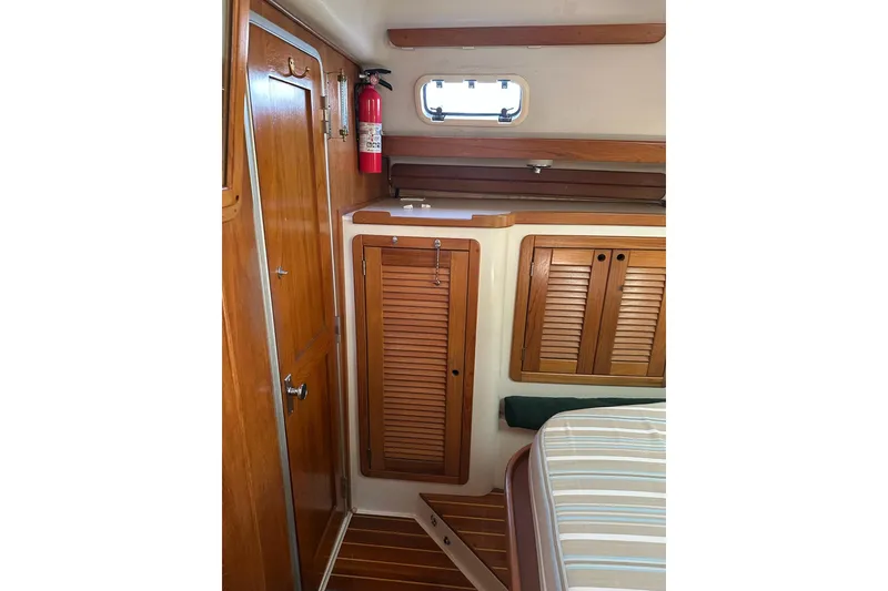 Slide: The Image of Interior of 1997 Catalina Morgan 38 sailboat with wooden cabinetry and fire extinguisher. - 59