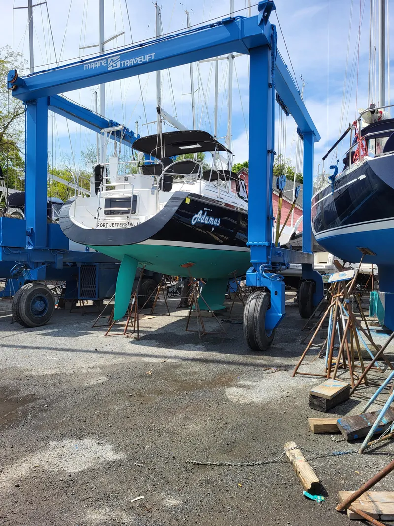 Slide: The Image of 1997 Catalina Morgan 38 sailboat in dry dock, supported by a blue travel lift. - 6