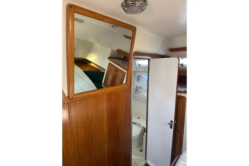 Slide: The Image of 1997 Catalina Morgan 38 yacht interior with wooden paneling and compact bathroom. - 62