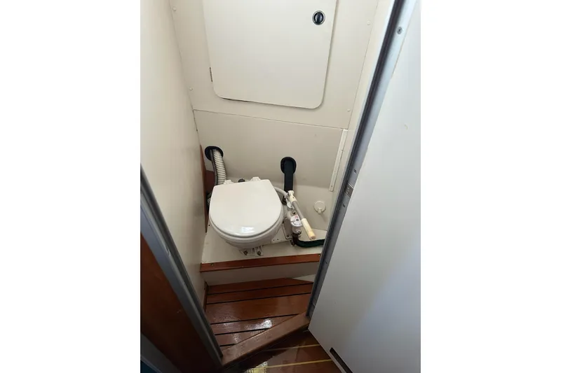 Slide: The Image of 1997 Catalina Morgan 38 boat bathroom with compact toilet and wooden flooring. - 74
