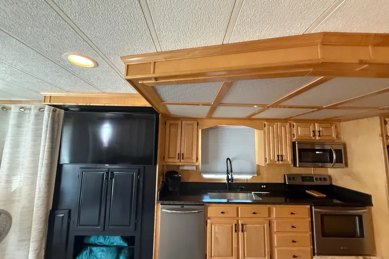 Slide: The Image of Interior of 2003 Horizon houseboat kitchen with wooden cabinets and modern appliances. - 12